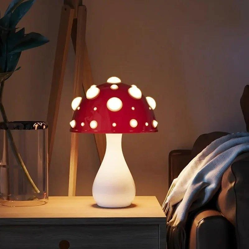 Zwei pilzförmige Tischlampen, eine große drahtgebundene und eine kleine drahtlose, die auf einem Regal sanft leuchten