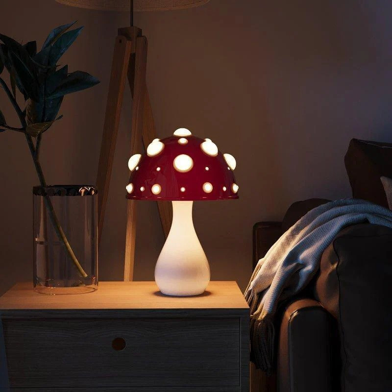 Zwei pilzförmige Tischlampen, eine große drahtgebundene und eine kleine drahtlose, die auf einem Regal sanft leuchten