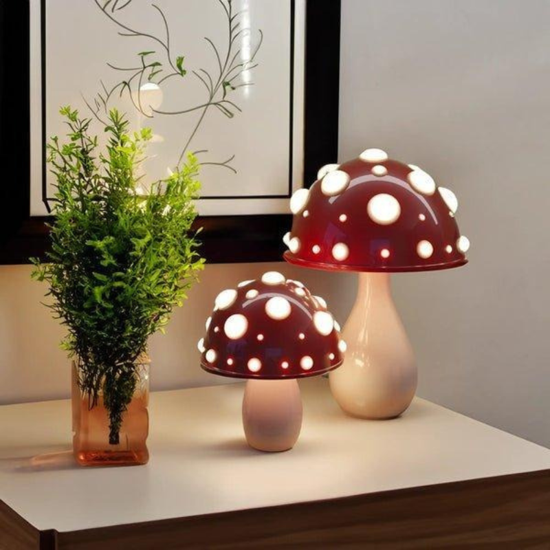Zwei pilzförmige Tischlampen, eine große drahtgebundene und eine kleine drahtlose, die auf einem Regal sanft leuchten
