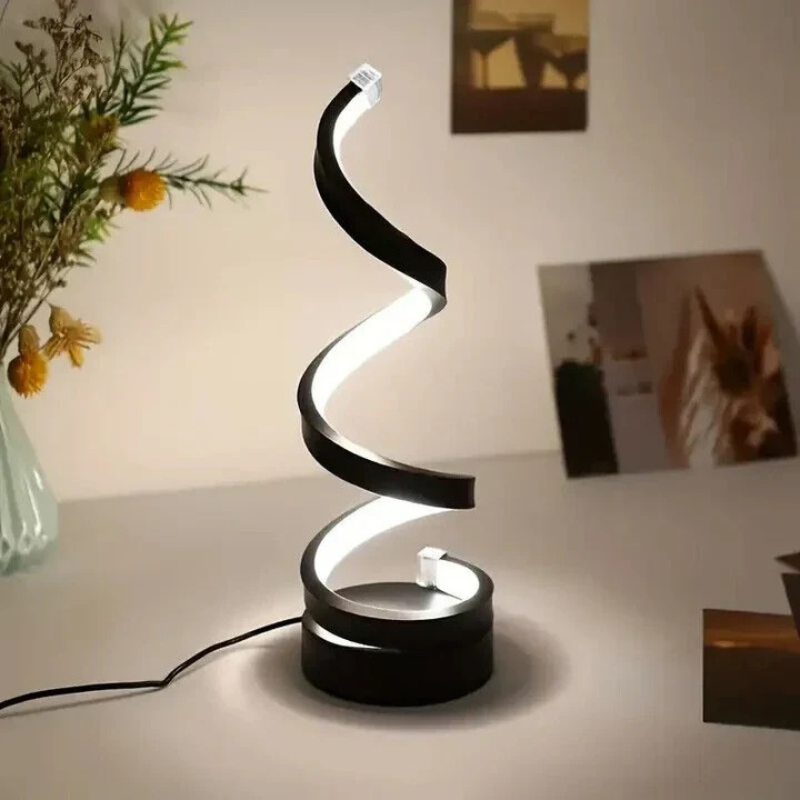 Moderne spiralförmige LED-Tischlampe, die auf einem hölzernen Beistelltisch in einem gemütlichen Interieur warm leuchtet
