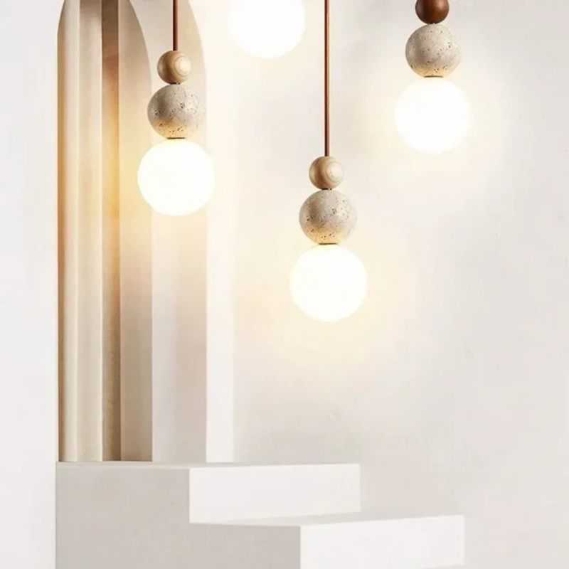 Moderne Pendelleuchte aus Travertin und Mahagoni mit warmem Licht, an einer Schnur aufgehängt, geeignet für Wohn- oder Essbereiche.