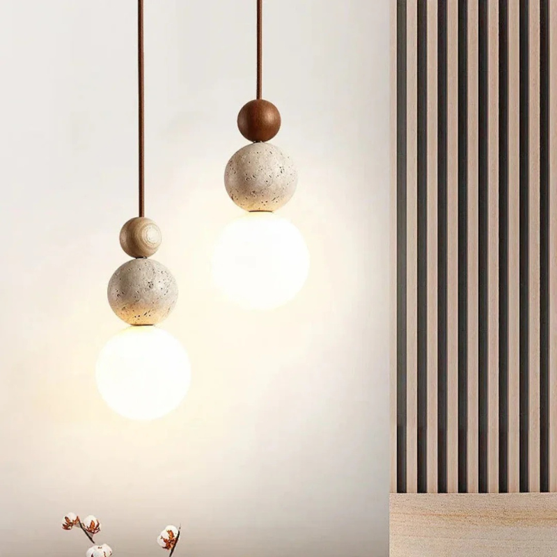 Moderne Pendelleuchte aus Travertin und Mahagoni mit warmem Licht, an einer Schnur aufgehängt, geeignet für Wohn- oder Essbereiche.