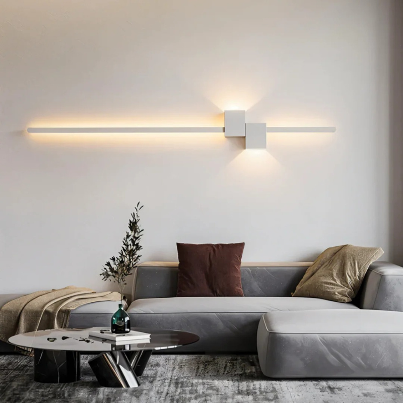 Moderne minimalistische LED-Wandleuchte in Schwarz, Weiß und Gold, die warmes weißes Licht für elegante Innenräume spendet.