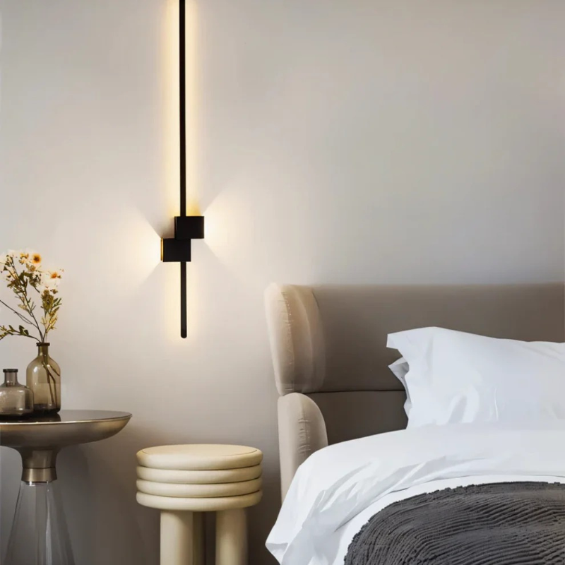 Moderne minimalistische LED-Wandleuchte in Schwarz, Weiß und Gold, die warmes weißes Licht für elegante Innenräume spendet.