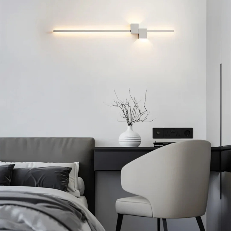Moderne minimalistische LED-Wandleuchte in Schwarz, Weiß und Gold, die warmes weißes Licht für elegante Innenräume spendet.