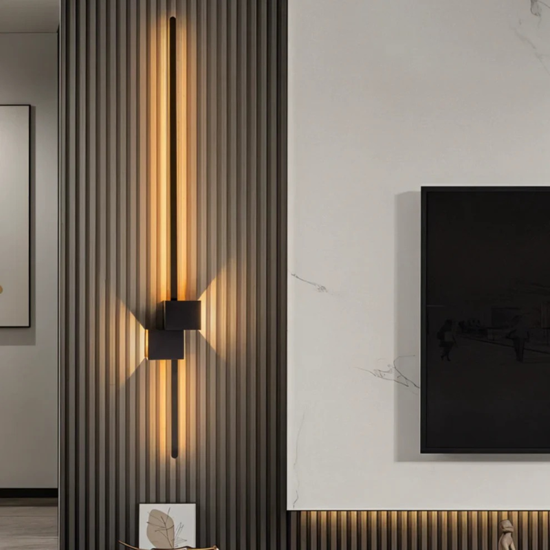Moderne minimalistische LED-Wandleuchte in Schwarz, Weiß und Gold, die warmes weißes Licht für elegante Innenräume spendet.